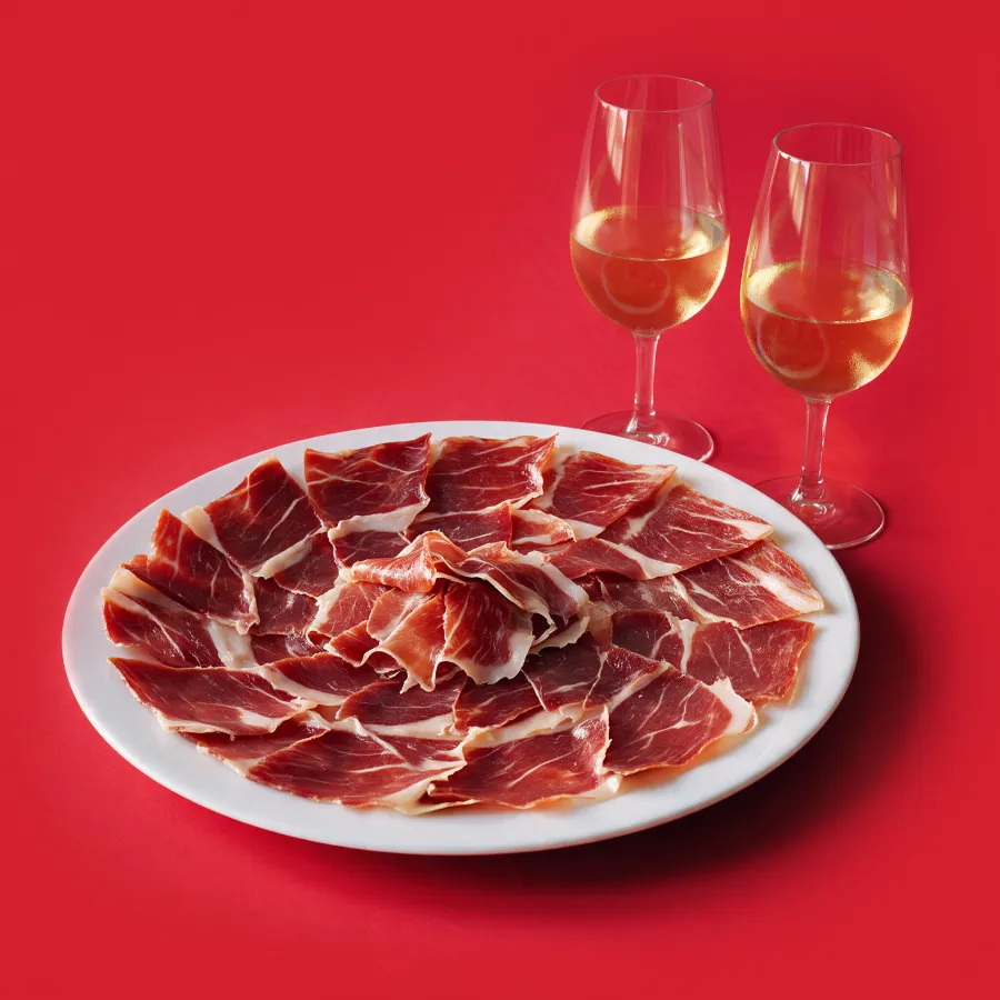 Plato de jamón ibérico y dos copas de vino fino