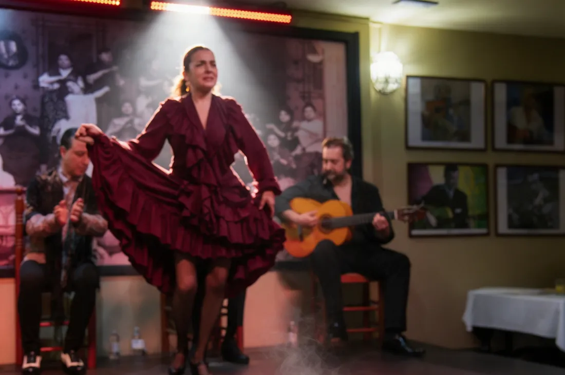 Danseuse et guitaristes sur la scène de La Cantaora, avec la fresque d'époque au fond